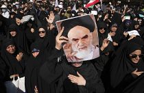 Γυναίκες καλυμμένες με μαύρα κρατούν φωτογραφίες του Αγιατολάχ στη διαδήλωση της Τεχεράνης