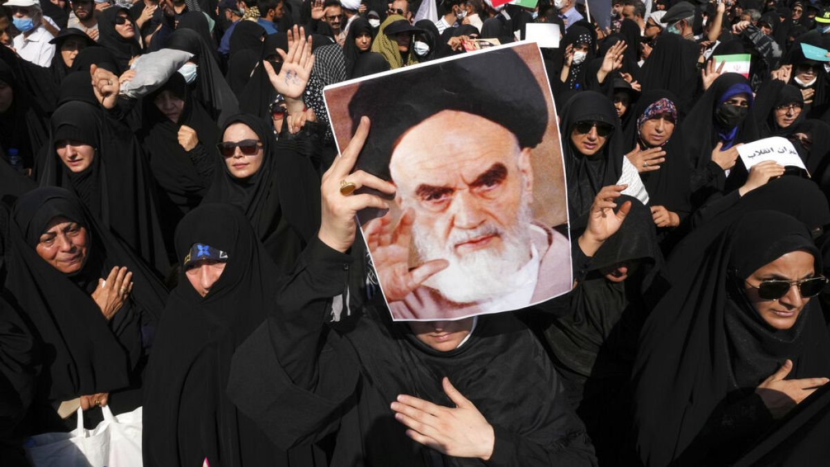 A pro-government demonstrator holds a poster of the late Iranian revolutionary founder Ayatollah Khomeini