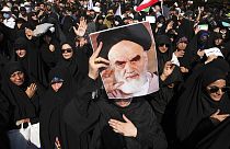 A pro-government demonstrator holds a poster of the late Iranian revolutionary founder Ayatollah Khomeini