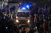 Red Cross ambulances carrying bodies of those died on a boat carrying migrants from Lebanon that sank in Syrian waters
