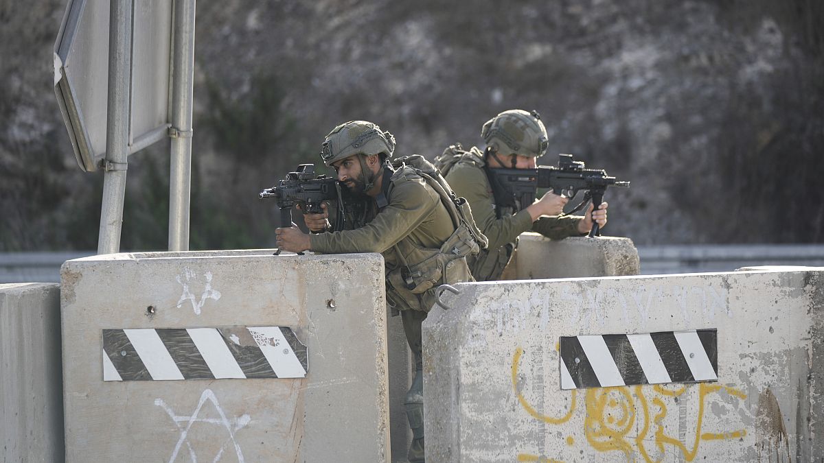 جنود إسرائيليون يتخذون مواقعهم عند حاجز بالقرب من مدينة نابلس بالضفة الغربية