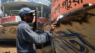 عامل يقوم بلحام مركب في دكا في 22 يونيو 2022