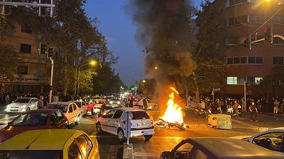 Протестующие сожгли полицейский мотоцикл в ходе выступлений в Тегеране 25 сентября 2022