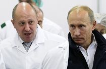 In this Sept. 20, 2010, file photo, businessman Yevgeny Prigozhin, left, shows Vladimir Putin around his facility that produces school meals outside St. Petersburg