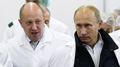 In this Sept. 20, 2010, file photo, businessman Yevgeny Prigozhin, left, shows Vladimir Putin around his facility that produces school meals outside St. Petersburg