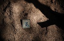 Icône sur le sol entre des tombes vides après l'exhumation de corps dans une fosse commune découverte à Izyum en Ukraine après l'invasion russe - 25.09.2022