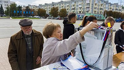 Une femme déposant son bulletin de vote lors d'un référendum à Lougansk, samedi 24 septembre 2022.