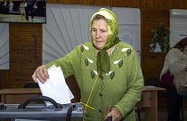 Eine Frau wirft in Luhansk einen Wahlzettel in eine Urne