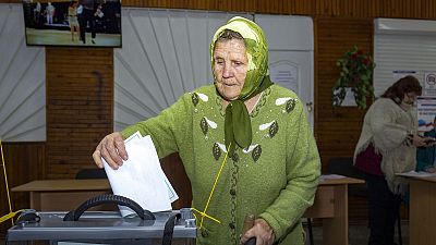 Eine Frau wirft in Luhansk einen Wahlzettel in eine Urne