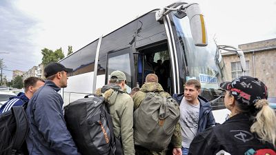 Hadkötelezettség alá vont orosz férfiak különbuszra szállnak egy sorozóirodánál az ukrán határnál levő Rosztov megyei Batajszkban 2022. szeptember 26-án.