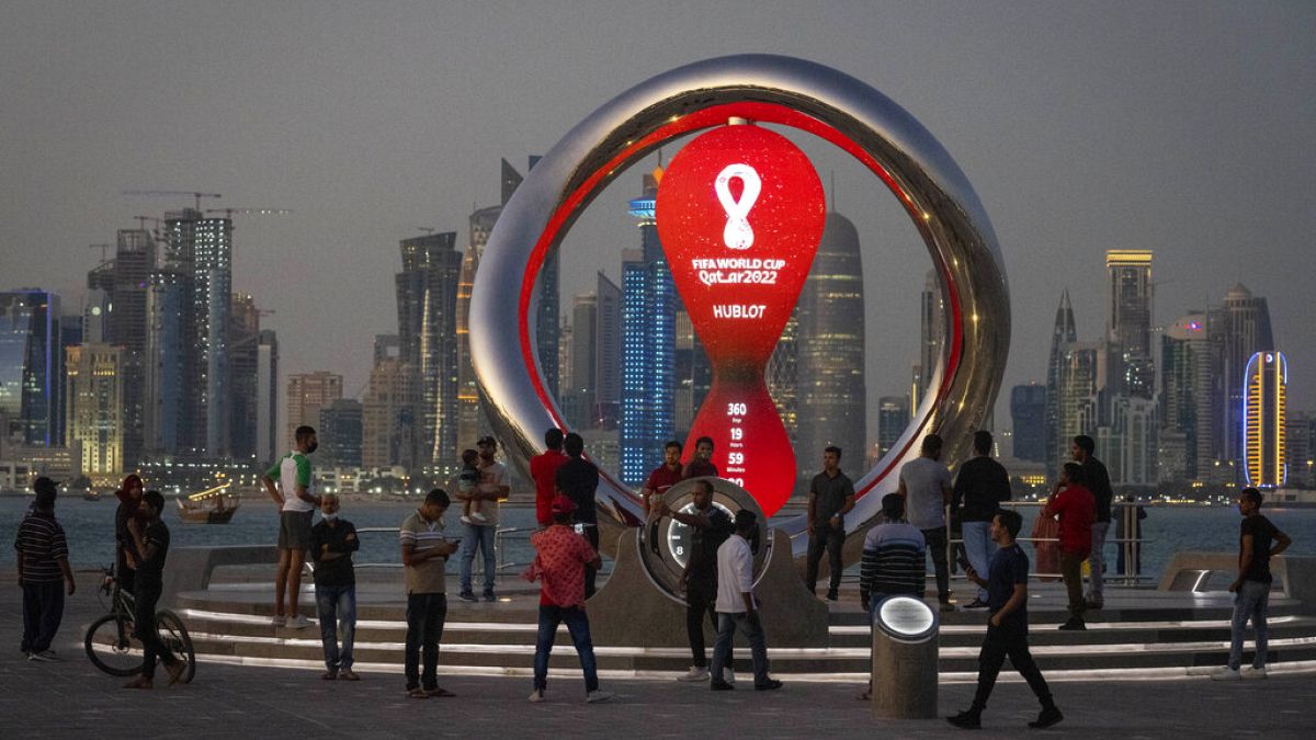 يتجمع الناس حول ساعة العد التنازلي الرسمية التي تظهر الوقت المتبقي حتى انطلاق مونديال 2022، الدوحة، قطر، 25 نوفمبر 2021