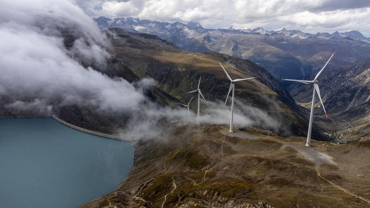 Windmills are seen in front of the Gries dam at SwissWinds farm, Europe's highest wind farm.
