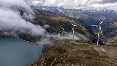 Windmills are seen in front of the Gries dam at SwissWinds farm, Europe's highest wind farm.