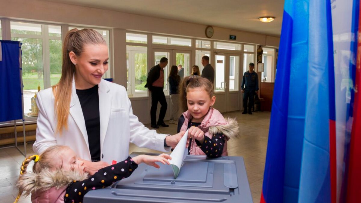 امرأة تصوت مع أطفالها في مركز اقتراع في لوهانسك، جمهورية لوغانسك الشعبية، أوكرانيا، 27 سبتمبر 2022