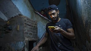 محروس محمود، البالغ من العمر 28 عامًا، ينظر إلى هاتفه وهو يسير على درج المبنى الذي يعيش فيه، في منفلوط، جنوب القاهرة في محافظة أسيوط، في 9 مايو 2020