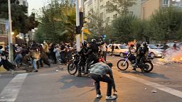 Motoros rendőrök gumibottal egy tüntetésen Teheránban