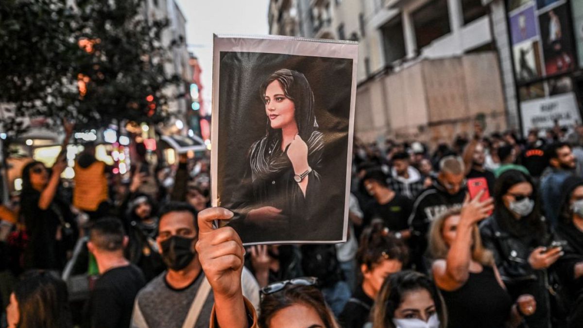 Amini'nin resmini taşıyan protestocu