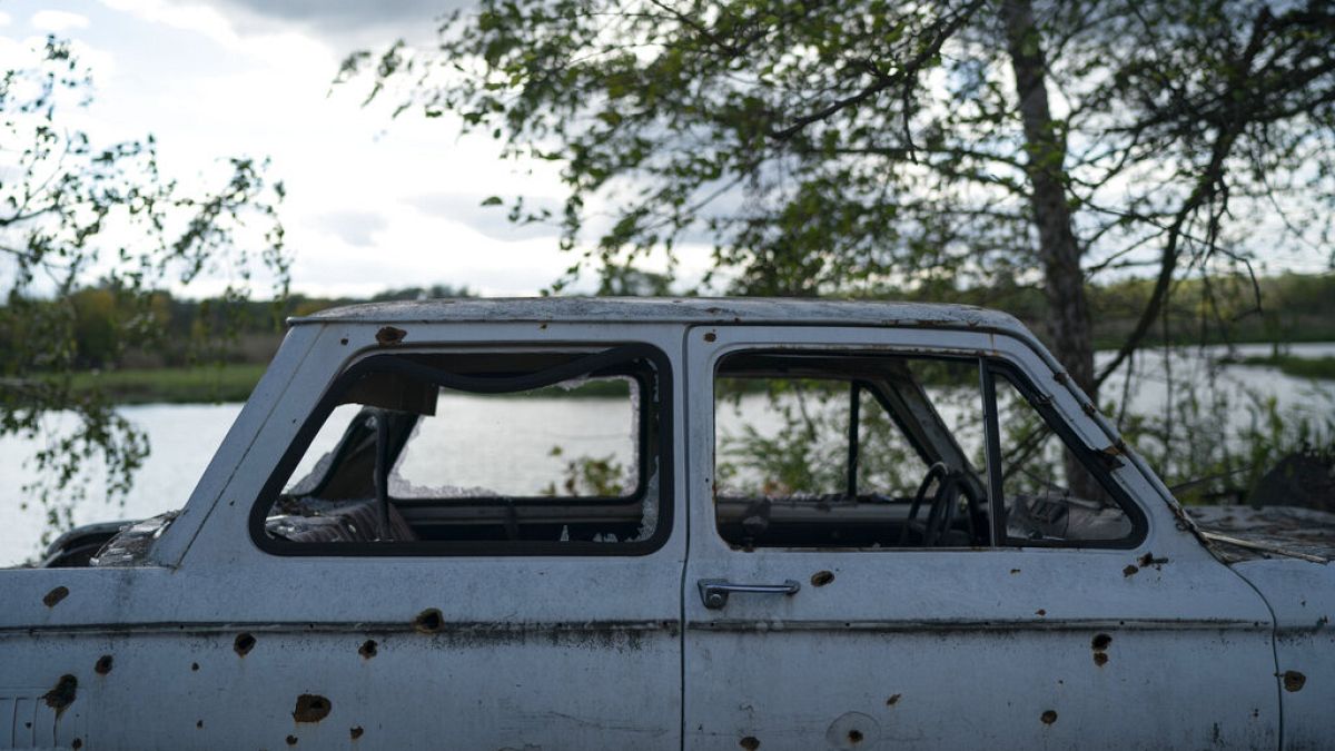 Ein von Granatsplittern beschädigtes Auto in dem zurückeroberten Dorf in der Ostukraine