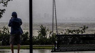Un hombre observa el retroceso de las aguas a causa de la marea baja y los fuertes vientos del huracán Ian a la distancia en Tampa, Florida, el 28 de septiembre de 2022.