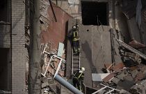 Mentőalakulatok tagjai egy orosz támadásban megrongálódott iskolaépület romjai között a dél-ukrajnai Mikolajvkában szeptember 28-án