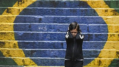 Un niño frente a los colores de la bandera de Brasil
