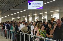 Amsterdam Schiphol Havaalanı'nda güvenlik kontrolünü geçmek için kuyrukta bekleyen yolcular