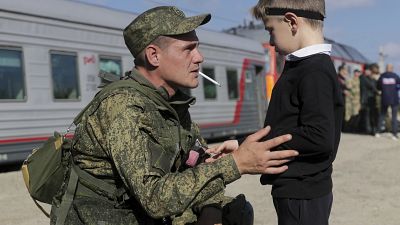 A Russian recruit speaks to his son prior to take a train at a railway station in Prudboi, Volgograd region of Russia, Thursday, Sept. 29, 2022