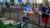 A man rests next to a Catalan flag during a pro-independence rally in Barcelona on September 11, 2022