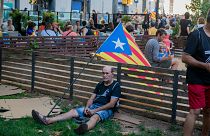 A man rests next to a Catalan flag during a pro-independence rally in Barcelona on September 11, 2022