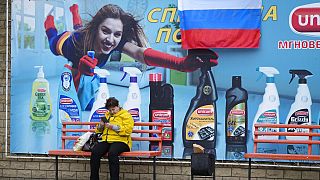 Eine Frau wartet an einer Bushaltestelle im russisch-besetzten Luhansk in der Ost-Ukraine am Tag nach dem dortigen Schein-Referendum