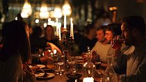 A group of diners have a drink and candle lit dinner at Brasserie Surrealiste in Brussels, Wednesday, Sept. 28, 2022.