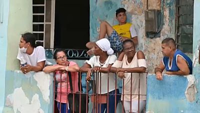 Cubanos observando el trabajo de limpieza que se está llevando a cabo en la isla tras el huracán Ian.