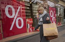 Une femme devant un magasin de Berlin, l'Allemagne atteint 11,9% d'inflation sur un an.