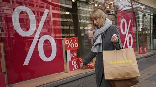 Une femme devant un magasin de Berlin, l'Allemagne atteint 11,9% d'inflation sur un an.