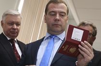 Un hombre sostiene un pasaporte ruso. 