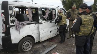 Police officers work near a damaged car after a Russian rocket attack in Zaporizhzhia, Ukraine