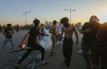 Des manifestants irakiens face aux gaz lacrymogènes lancés par les forces de sécurité à Bagdad, en Irak, samedi 1er octobre 2022.