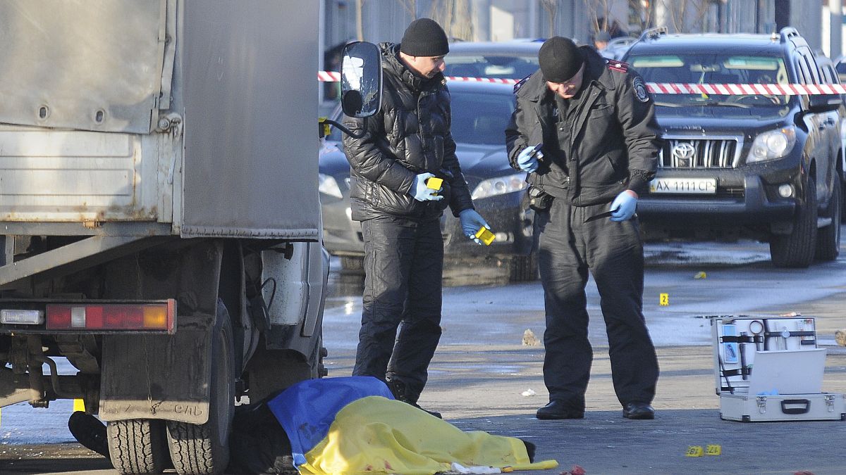 خبراء من الطب العدلي يعاينون جثة غطيت بالعلم الأوكراني بعد انفجار في خاركيف - أرشيف