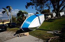 A sign placed by a resident asks that a boat that landed on their lawn during Hurricane Ian please be removed, in south Fort Myers, Fla., Saturday, Oct. 1, 2022.