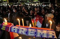 Aficionados al fútbol corean consignas durante una vigilia por los seguidores del Arema FC víctimas de los disturbios del sábado en Yakarta, Indonesia, el 2 de octubre de 2022