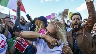 Eine Frau schneidet sich die Haare während einer Demonstration in Istanbul, Türkei, Sonntag, 2. Oktober 2022.