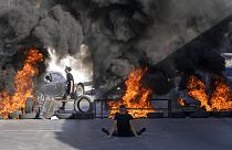 Neumáticos arden en una barricada construida por manifestantes en Cisjordania.