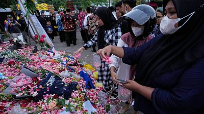 Des personnes déposent des fleurs en hommage aux victimes de la bousculade survenue samedi lors d'un match de football à Malang en Indonésie - 03.10.2022