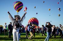 Nicole Tagart, a launch official with the 50th annual Albuquerque International Balloon Fiesta, signals a balloonist to take off.