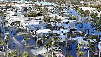 Water floods a damaged trailer park in Fort Myers