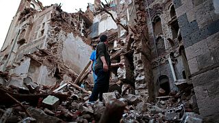 يمنيون يتفقدون مبنى مدرج على قائمة اليونسكو في مدينة صنعاء القديمة، أغسطس 2022