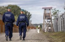 Operational police officers walk along the service route of Hungary's border with Serbia near Roszke, Southern Hungary, Wednesday, Sept. 28, 2022.