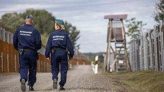 Operational police officers walk along the service route of Hungary's border with Serbia near Roszke, Southern Hungary, Wednesday, Sept. 28, 2022.