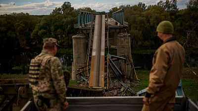 Soldats ukrainiens sur un pont endommagé lors de combats avec les troupes russes à Izioum, en Ukraine, lundi 3 octobre 2022.