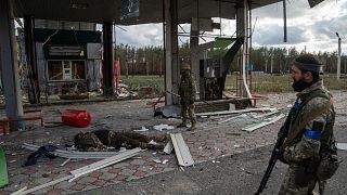 Militares ucranianos encuentran el cuerpo de un compañero en una estación de servicio destruida en la recientemente reconquistada ciudad de Limán, Ucrania, el 3 de octubre.